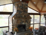 Interior view of Screen Room with stone fireplace & knotty pine ceiling